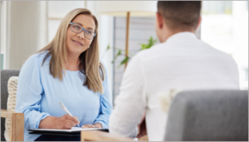 Woman with clipboard talking to a man